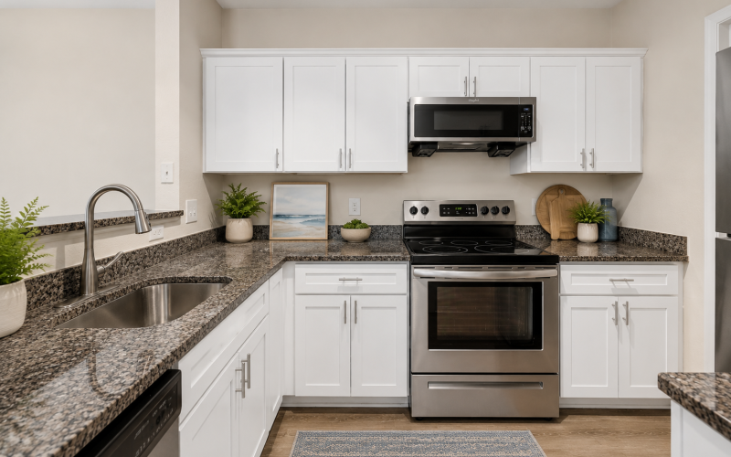 Kitchen with granite countertops, white cabinetry and stainless steel appliances