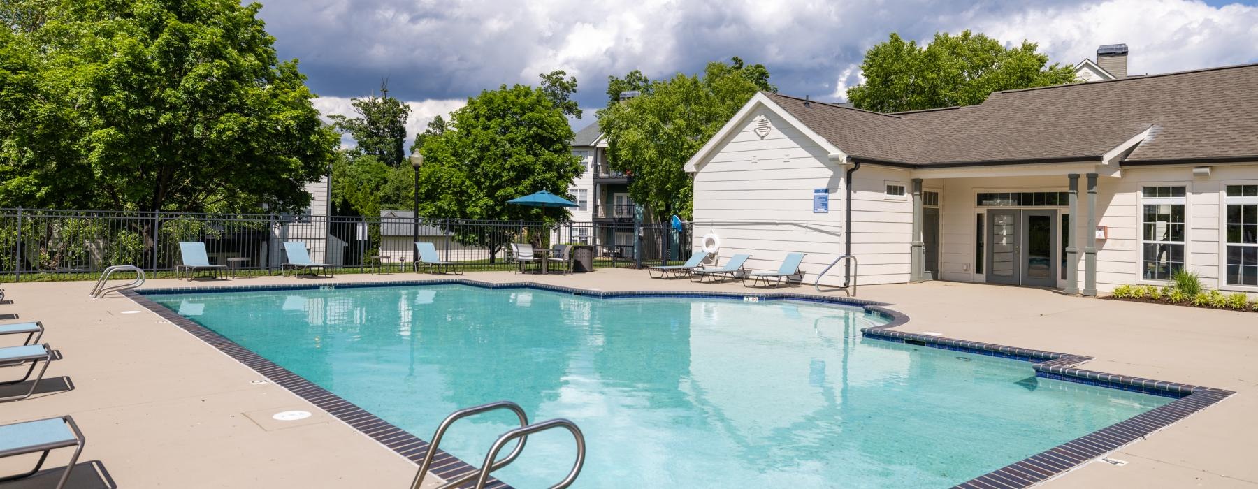 a swimming pool with a house in the background