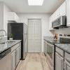 Kitchen with granite countertops, white cabinetry and stainless steel appliances