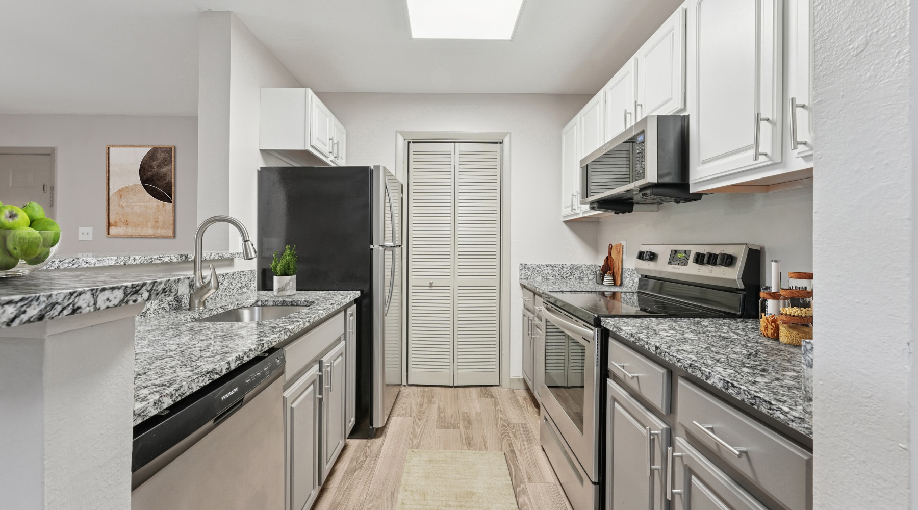 Kitchen with granite countertops, white cabinetry and stainless steel appliances